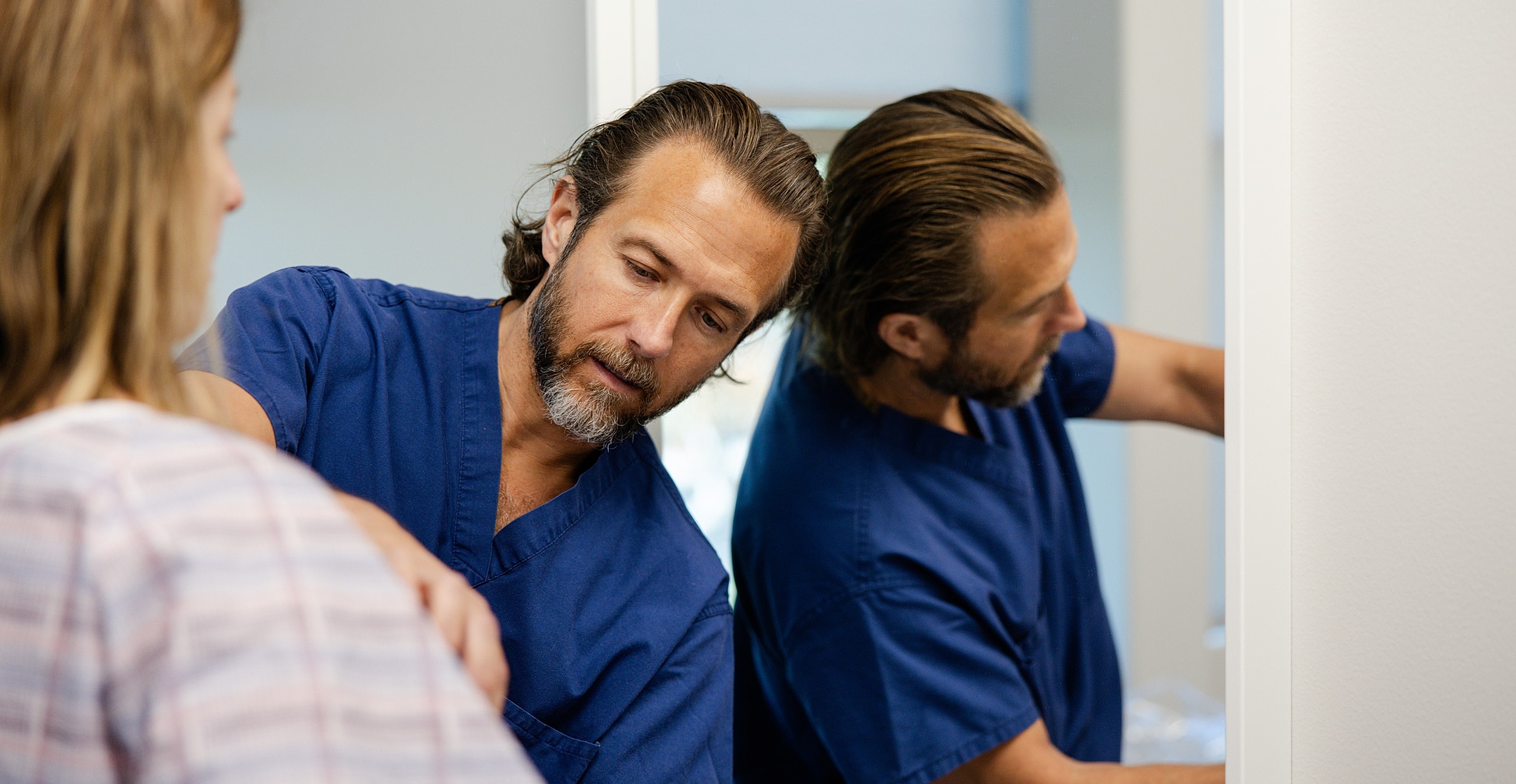 Doctor examining patient in clinic setting.