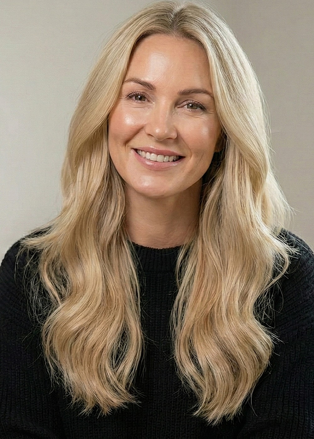 Smiling woman with long wavy blonde hair.