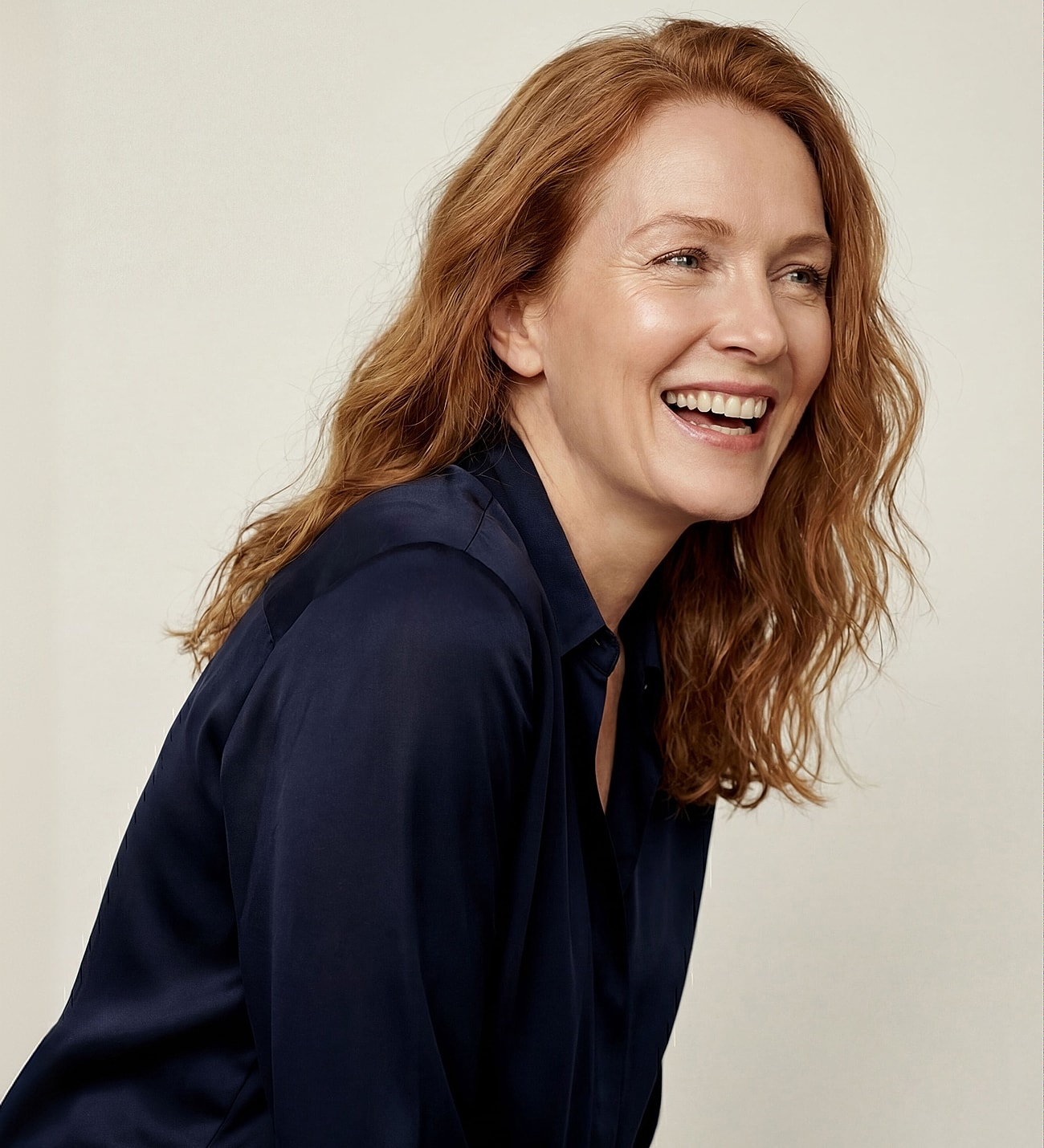 Smiling woman with wavy red hair.