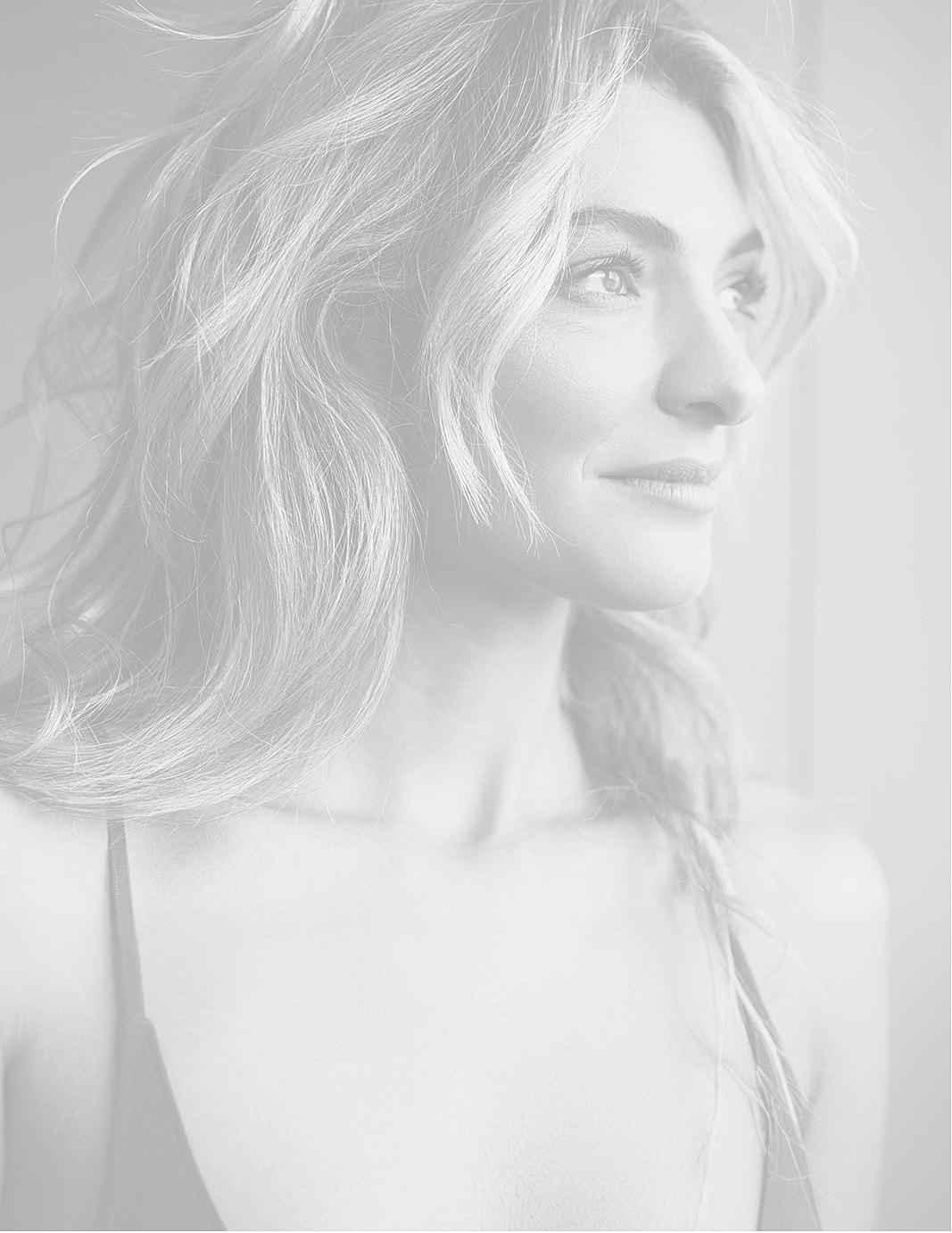 Woman with long hair gazing thoughtfully to side.