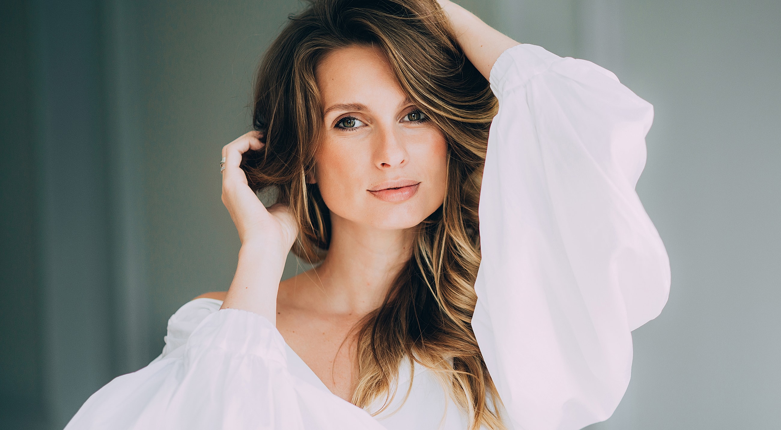 Woman in white blouse with flowing hair.