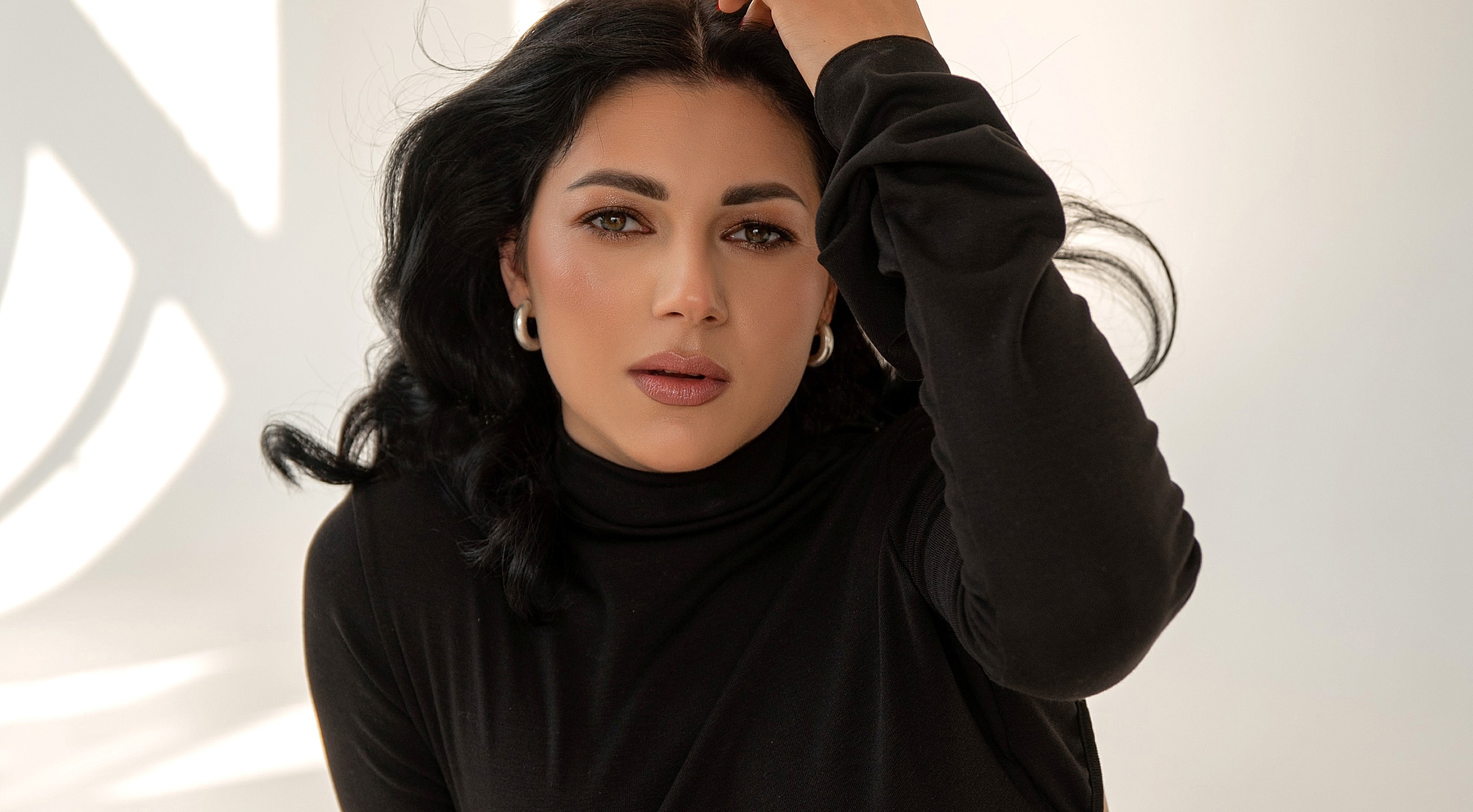 Woman with dark hair wearing a black turtleneck.
